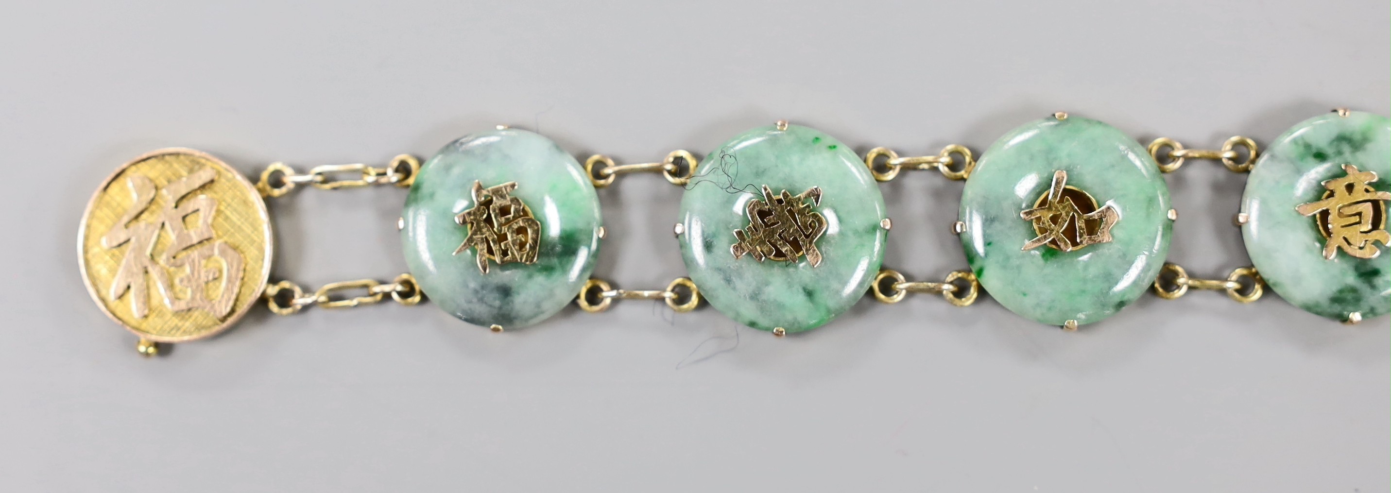 A Chinese 18k yellow metal and jadeite disc link set bracelet, 17.5cm, gross weight 20.6 grams.